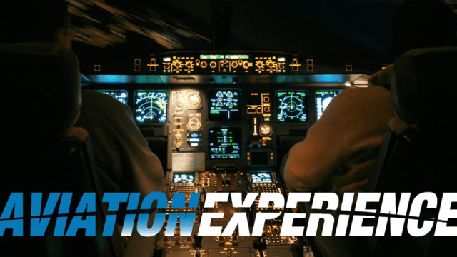 Dark airplane cockpit with two pilots, illuminated by numerous glowing instruments and "AVIATION EXPERIENCE" text.